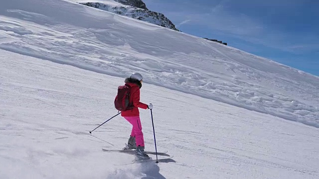 在运动中，女子滑雪者滑雪下山的山坡上视频素材