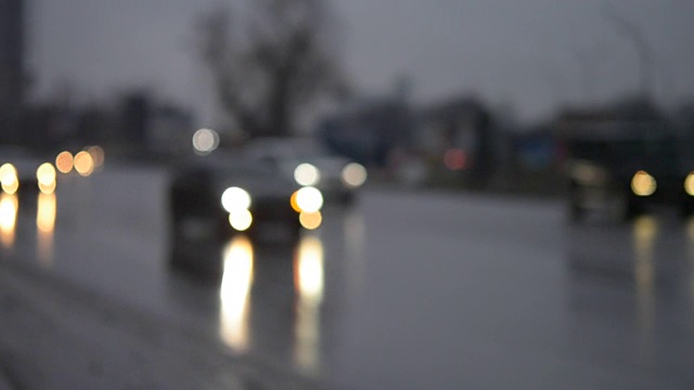 黄昏的黑暗中，汽车在潮湿的道路上行驶视频素材