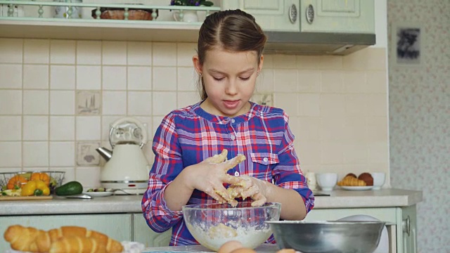 可爱的小女孩在厨房里微笑着做面团和清洁双手。她想用烤饼干给她妈妈一个惊喜视频素材