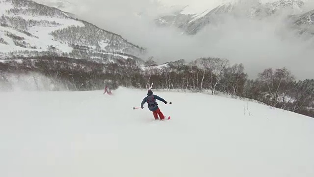 滑雪者在厚厚的雪粉中下山视频素材