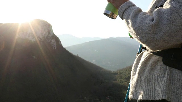 日出时分，女徒步旅行者在山谷上空放松视频素材