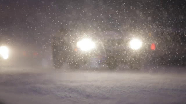 在暴风雪的夜晚，汽车从旁边驶过视频素材