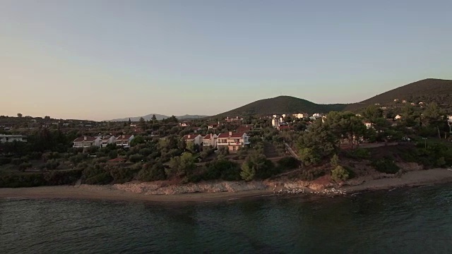 航拍的特里科弗海滩海岸的小屋和绿色山丘，希腊视频素材