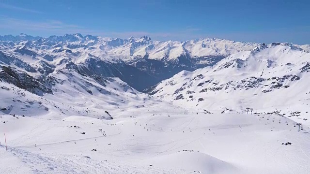 令人叹为观止的雪山全景和滑雪者在斜坡上视频素材