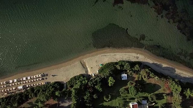 飞越海滨度假胜地。海滩上的日光浴床和海滨别墅视频素材