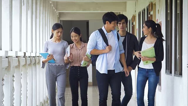 一群年轻的亚洲学生青少年用学校文件夹学习阅读书籍去教室在校园。教育与青少年观念视频素材