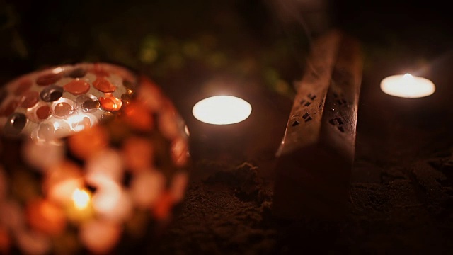 熏香和蜡烛燃烧和烟在黑暗的背景。熏香和蜡烛的烟视频素材