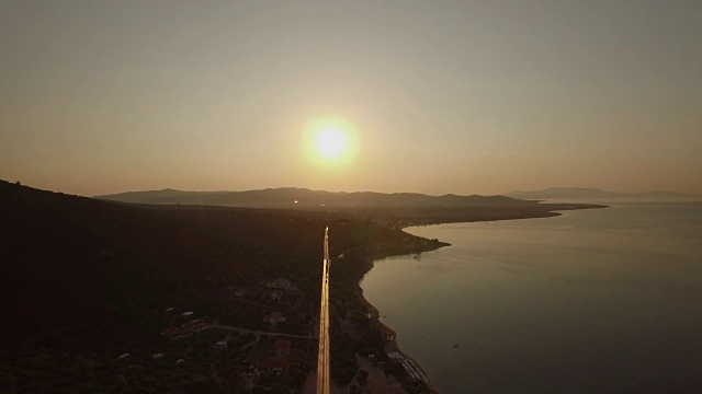 飞过Trikorfo海滩海岸线和海滨道路在日落，希腊视频素材