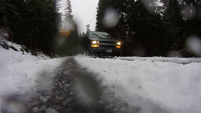 面包车在雨中的雪和雪中驶过视频素材