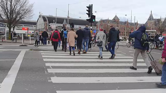 阿姆斯特丹中央火车站前的有轨电车和旅客视频素材