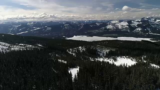 在雪山太阳常绿树木森林空中视频素材