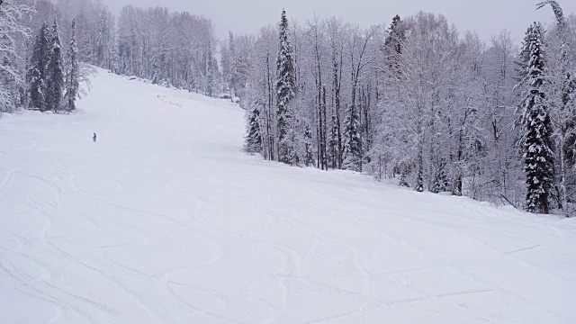 Teletsky阿尔泰冬季高山滑雪胜地。人们在山上滑雪，森林背景下下雪视频素材