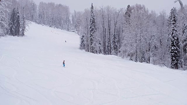 Teletsky阿尔泰冬季高山滑雪胜地。人们在山上滑雪，森林背景下下雪视频素材