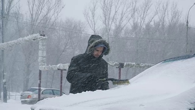 男子清理汽车上的积雪视频素材