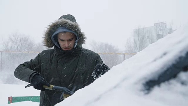 一名男子正在清理车上的积雪视频素材