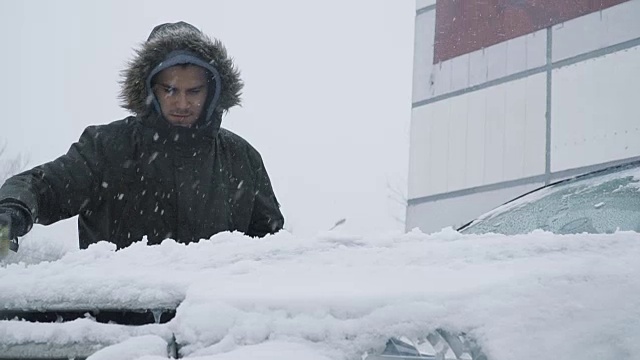 一名男子正在清理车上的积雪视频素材