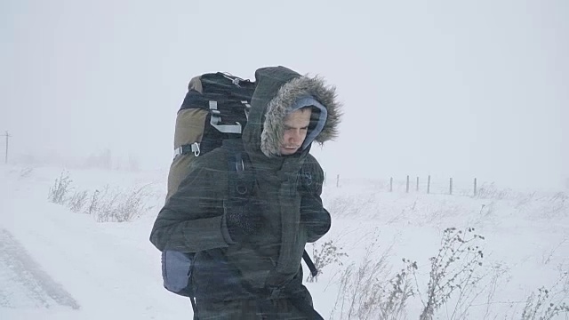 一个年轻人正穿过暴风雪视频素材