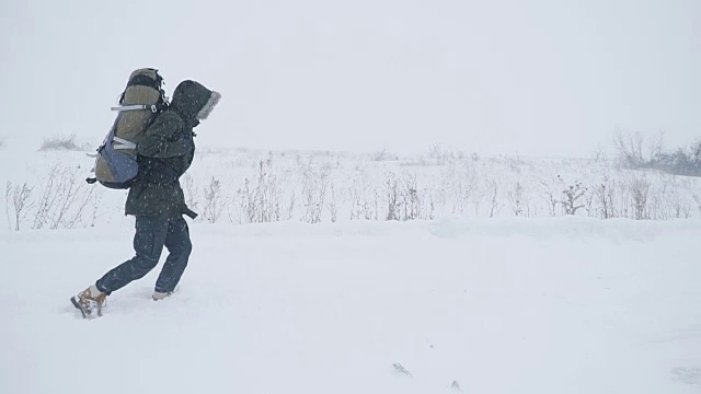 一个年轻人正穿过暴风雪视频素材