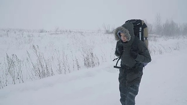 一个年轻人正穿过暴风雪视频素材