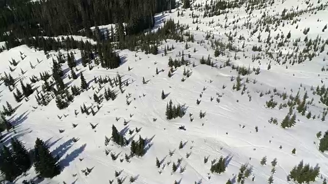 雪地摩托在雪地高无人机飞下来视频素材