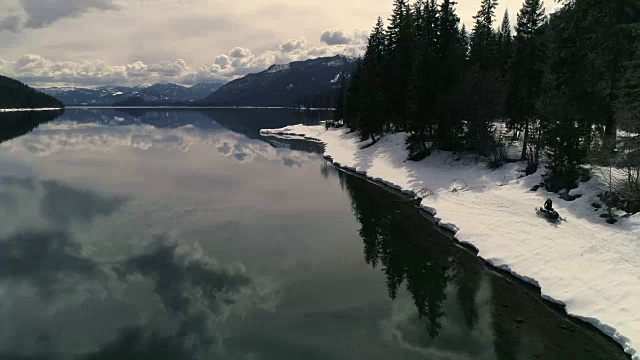 在湖边的荒野雪地摩托探险视频素材