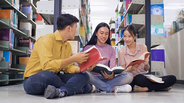 一群年轻的亚洲学生带着书在大学图书馆做研究，学习教育和学校理念视频素材