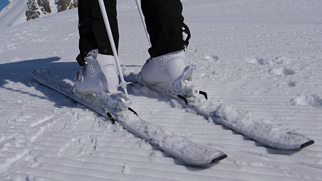 近距离女子滑雪者解开山滑雪靴使用棍棒视频素材