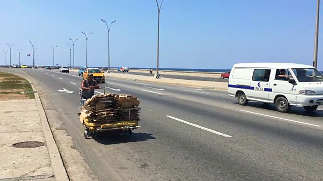 古巴哈瓦那:Malecon大街，一名男子正在运送可回收的纸箱视频素材