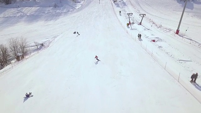 空中拍摄从飞行无人机人滑雪和滑雪场雪坡滑雪板。雪山上的滑雪电梯。冬季滑雪胜地的活动视频素材