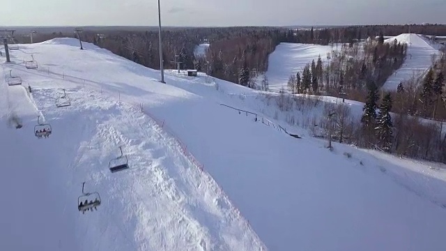 滑雪电梯，用于运输滑雪者和滑雪板在雪山滑雪场鸟瞰图。滑雪缆车在滑雪坡的绳索道无人机拍摄视频素材