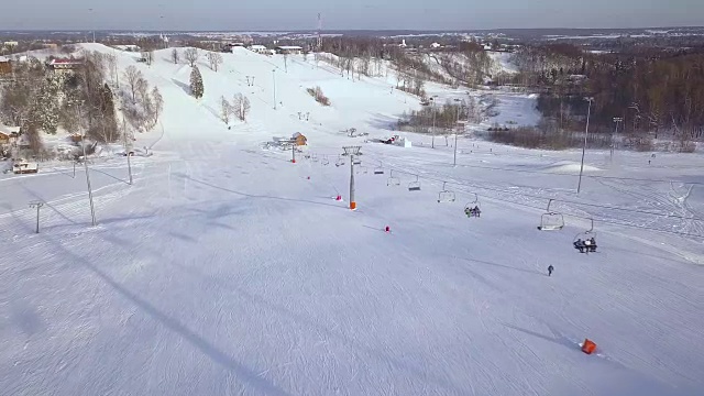 人们在滑雪山上移动缆车在冬季度假村鸟瞰图。滑雪电梯，用于在滑雪胜地的雪山上运输滑雪者和滑雪板视频素材