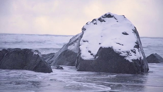 罗弗敦群岛。海滩上的积雪岩石视频下载