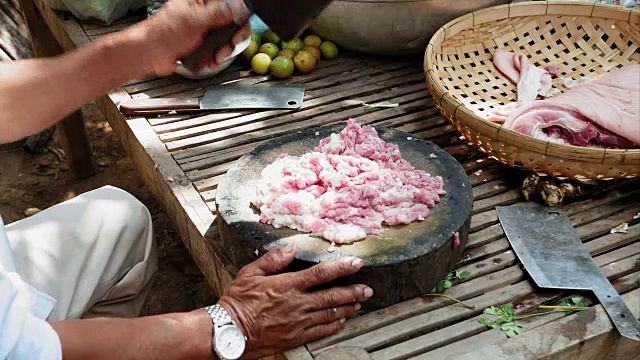 肉贩用切肉刀在圆形木砧板上切一片猪视频素材