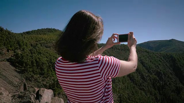 女孩将在电话上拍摄火山泰德视频素材