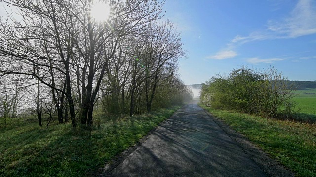 田野路与两个慢跑者和阳光在春天，Wertheim, Spessart, Franconia, Baden-Württemberg，德国视频素材