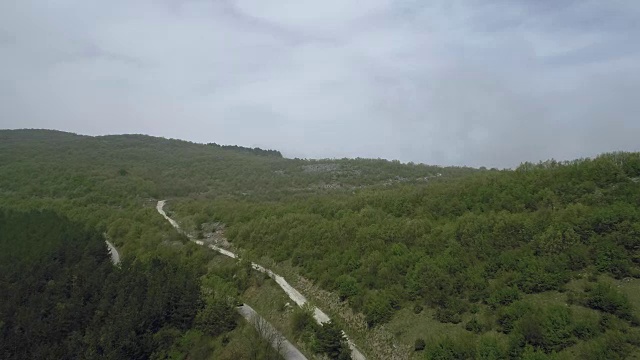 鸟瞰图上弯曲的柏油路与汽车在山区视频素材