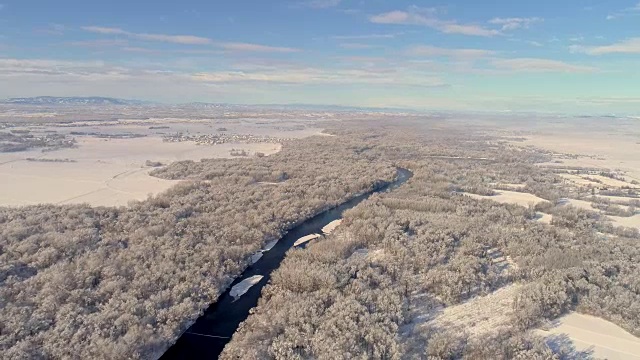 WS鸟瞰图河流之间的雪域乡村景观，穆拉河，普雷克穆里耶，斯洛文尼亚视频素材