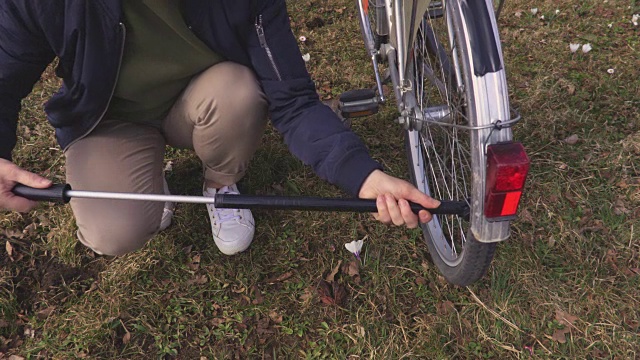 给自行车轮胎打气的女人视频素材