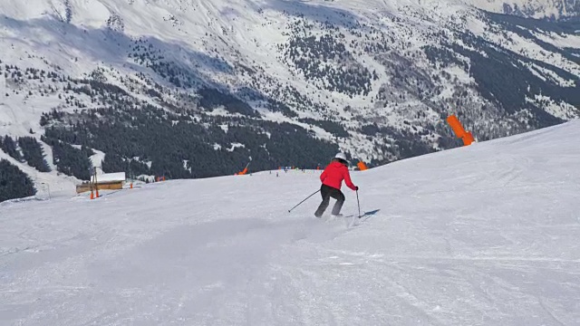 成熟的女子滑雪者滑雪下山坡在山上在冬天和刹车视频素材