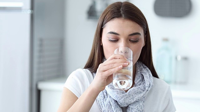 年轻女子喝了一杯水视频素材