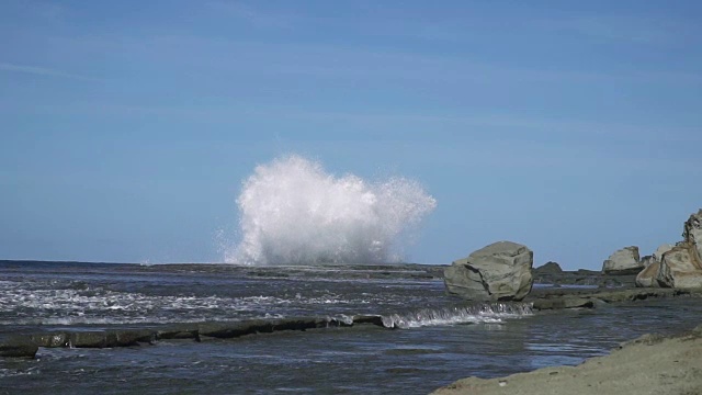 慢镜头海浪撞击海岸岩石，溅起巨大水花视频素材