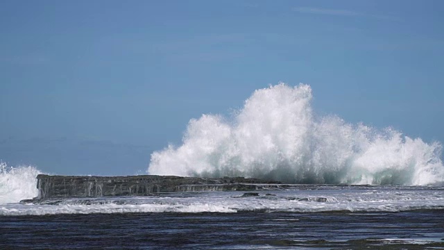 慢镜头海浪撞击海岸岩石，溅起巨大水花视频素材