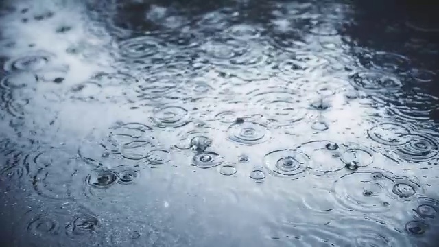 雨点缓慢地落在人行道上。视频素材