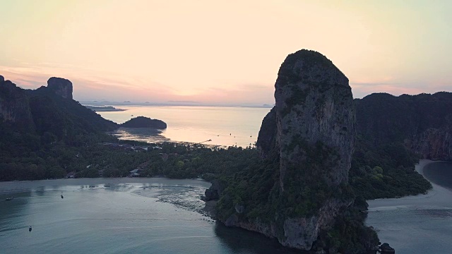 天线:平静的海浪慢慢地滚向悬崖附近的空旷沙滩。视频素材