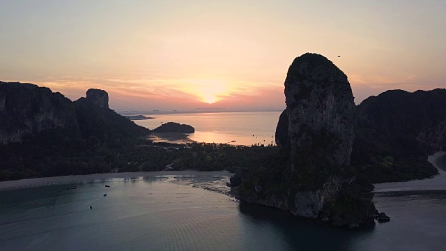 航拍:令人惊叹的夏日日落照耀在遥远的天堂岛村庄和海滩上视频素材