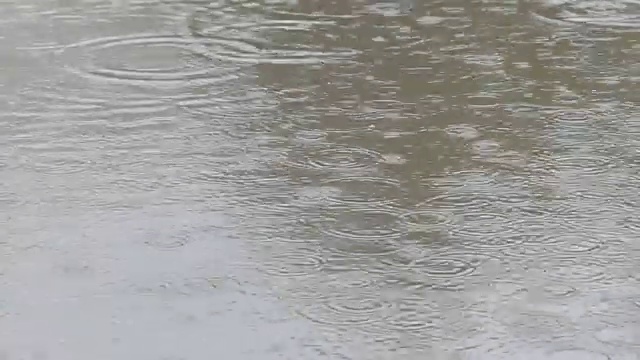 雨滴在水中形成有趣的涟漪和气泡图案视频素材