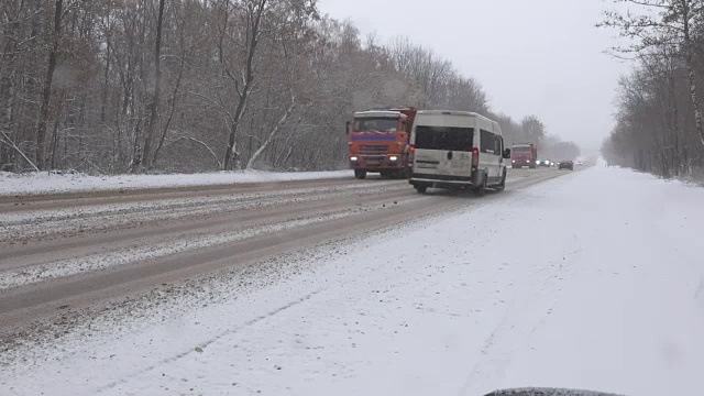 暴风雪期间冬日路上的汽车视频素材