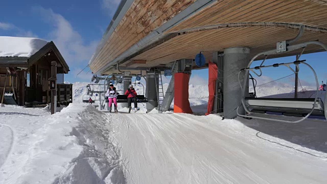 滑雪者坐着轮椅爬上山顶，然后在斜坡上离开视频素材