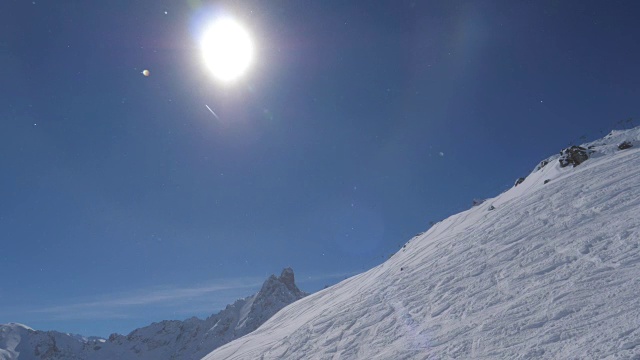 在明亮的太阳与光晕和飞行的飞机冬天雪山的观点视频素材