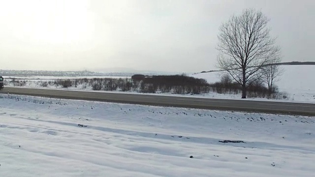 航拍卡车在雪地里行驶的冬季道路。视频素材